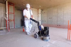 Equipos para Preparación de Superficies y Pulido - APV Chile Operario con equipo de protección utilizando maquinaria industrial para la preparación de superficies y pulido de pisos de concreto en una obra en Chile.