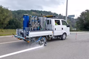 Maquinaria para Demarcación Vial y Carreteras - APV Chile Camión equipado con maquinaria de demarcación vial realizando el pintado de líneas termoplásticas en carreteras de Chile.
